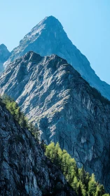 Sunlit alpine peak rising above layered rocky ridges.