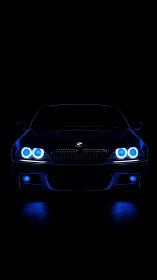 Front low‑key silhouette of sports coupe with blue LED halos