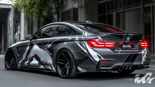BMW M4 coupe with monochrome geometric wrap in urban light.