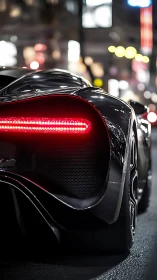 Rear view shows sleek black supercar with illuminated taillight