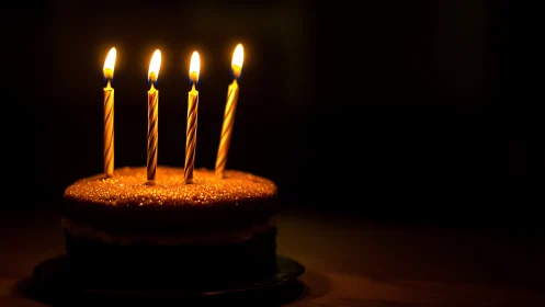 Golden Birthday Cake with Four Spiral Candles Against Dark Background