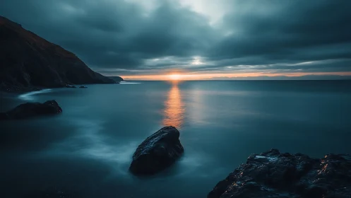 Long exposure coastal dusk with rocks and reflective horizon glow
