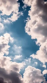 Gentle clouds drift apart to reveal a peaceful blue sky