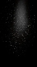 White particulate spray disperses against uniform black background
