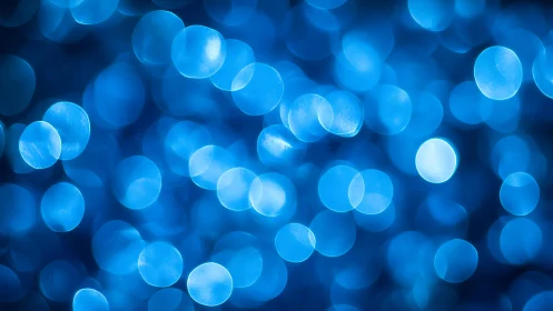 Abstract blue bokeh lights background with soft glowing circles.