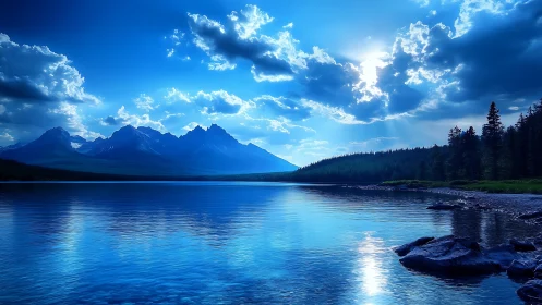 Blue mountain lake at sunrise under dramatic clouds.
