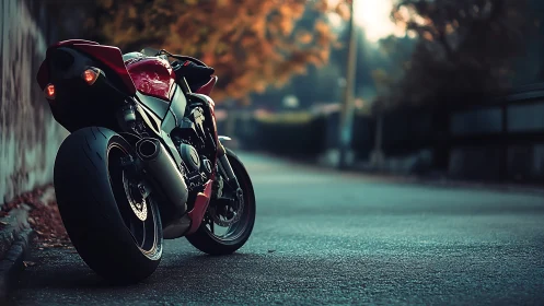 Red sport motorcycle at dusk on empty suburban street.