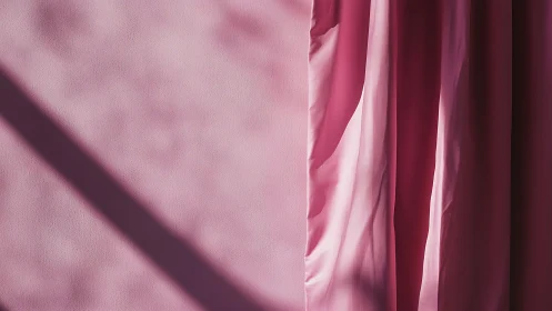 Sunlit pink curtain quietly folds light into soft shadow