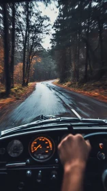 Driver steers classic car along wet forest road at speed