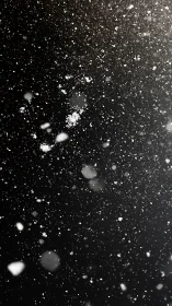 Snowflakes drift through dark night with soft bokeh glow.