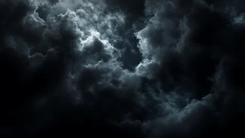 Moody storm clouds curl gently around a soft silver glow