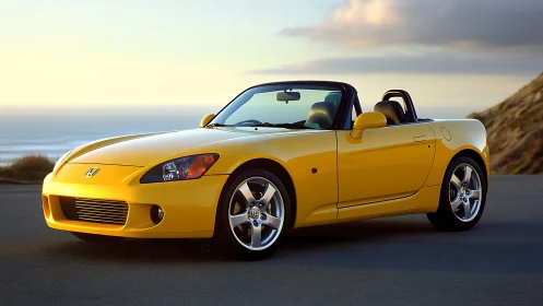 Yellow roadster coupe at coastal overlook during sunset.