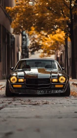 Black classic muscle car on empty street in autumn light.