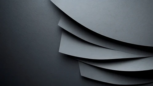 Curved graphite panels overlap in layered minimalist composition