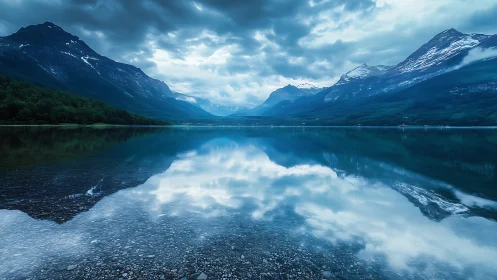 Quiet mountain lake cradled by clouds and soft reflections.