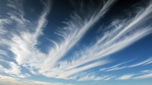 High altitude cirrus clouds stretching across blue sky.
