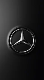 Chrome three-pointed star emblem on matte black surface.