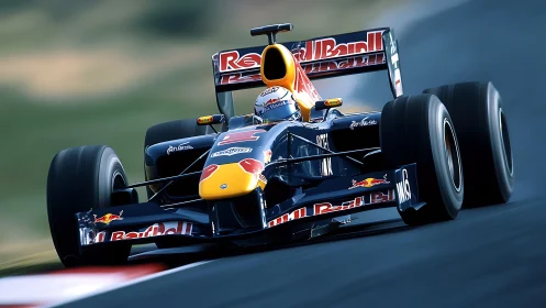 Red Bull Formula 1 car racing at high speed on track.