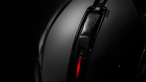 Sleek black gaming mouse macro shot with red LED accent lighting.
