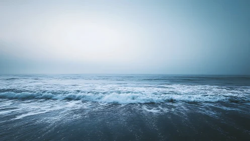 Gentle blue waves roll softly toward a calm open horizon