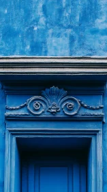 Serene blue doorway with ornate trim inviting quiet wonder.
