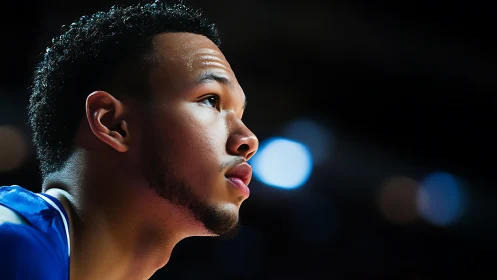 Male basketball player looks upward in focused side profile