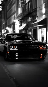 Muscle car prowls a dim city street in dramatic monochrome.