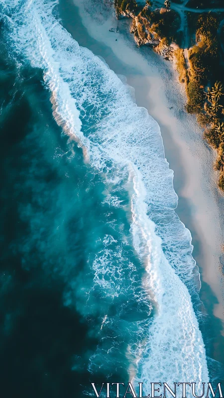 Aerial coastal shoreline with waves and sandy beach edge.