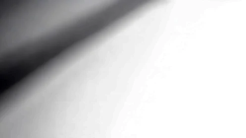 Monochrome diagonal shadow gradient across luminous plane.