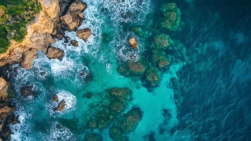 Turquoise surf collides with rugged coastal rock shelf.