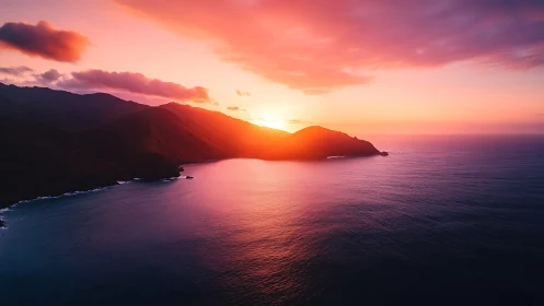 Coastal headland bathed in radiant magenta ocean sunset light.