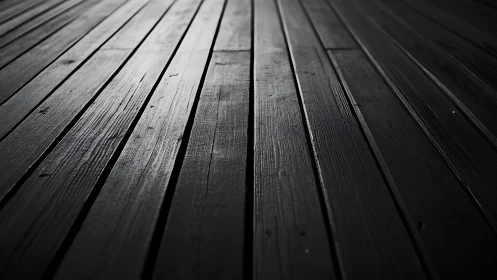 Low-key linear study of dark wooden floor planks in perspective.