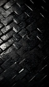 Angled black 3D tiles form wet, high-contrast geometric surface