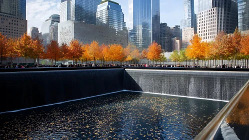 Urban memorial fountain framed by vivid autumn foliage.