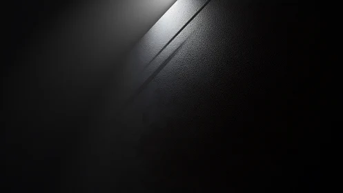 Soft light crossing a dark textured wall in quiet focus.
