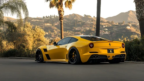 Yellow Ferrari coupe sits low under palm trees at sunset