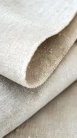 Curled natural linen fabric revealing fine woven texture.