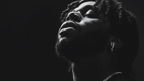 Upward gaze in dramatic monochrome portrait lighting.