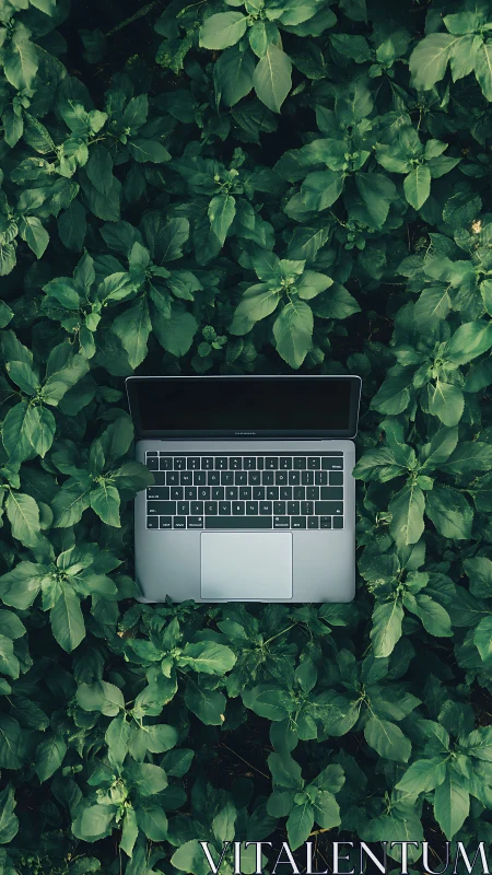Sleek laptop rests amid lush green foliage in nature.