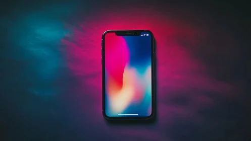 Smartphone with Neon Gradient Display Against Dark Ambient Backdrop.