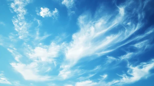 Wispy White Clouds in a Bright Blue Sky, Serene Nature Scene.