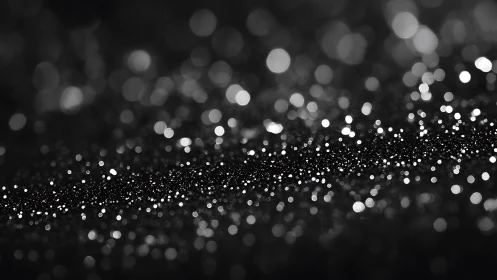 Glittering bokeh lights drift across a dark abstract surface