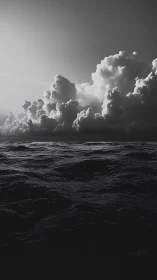Storm-lit cumulonimbus over dark monochrome ocean horizon.