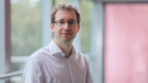Calm professional stands in soft pastel office daylight glow.