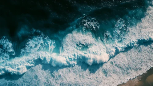 Aerial ocean surf crashes over turquoise coastal shallows.