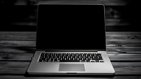 Photorealistic laptop on wooden desk in low key lighting.