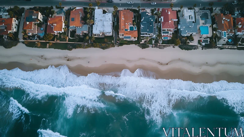Aerial coastal housing grid aligned against high energy surf