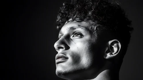 Side-lit male profile in high-contrast monochrome portrait