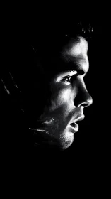 Stark monochrome profile carving light from deep shadow.