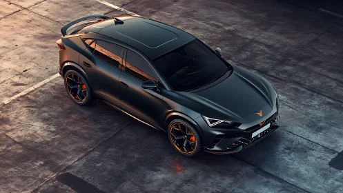 Dark metallic sports SUV on industrial concrete lot at dusk.